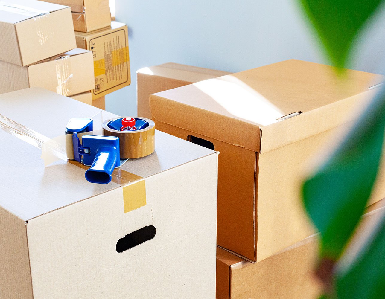 Cardboard boxes with packing tape ready for moving in a sunlit room